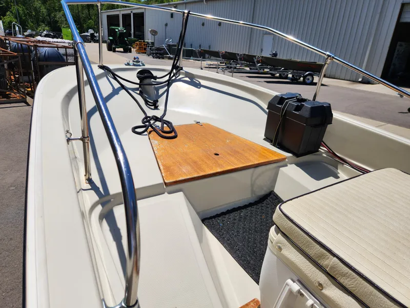 Slide: The Image of 1985 Boston Whaler 15 boat interior with wooden deck and cushioned seating. - 6