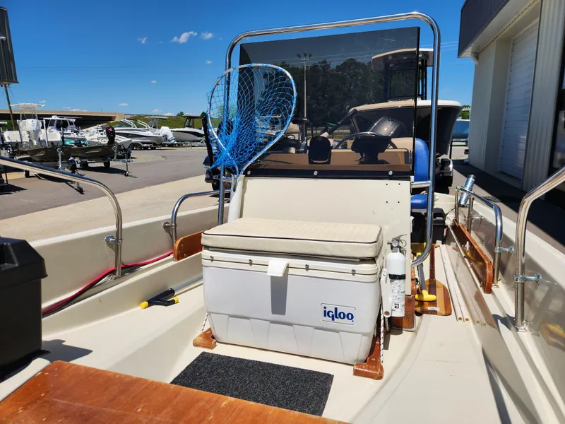 Slide: The Image of 1985 Boston Whaler 15 boat interior with Igloo cooler and fishing net on a sunny day. - 7