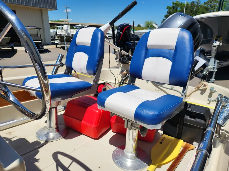 Slide: The Image of 1985 Boston Whaler 15 boat interior with blue and white seats, steering wheel, and engine. - 9