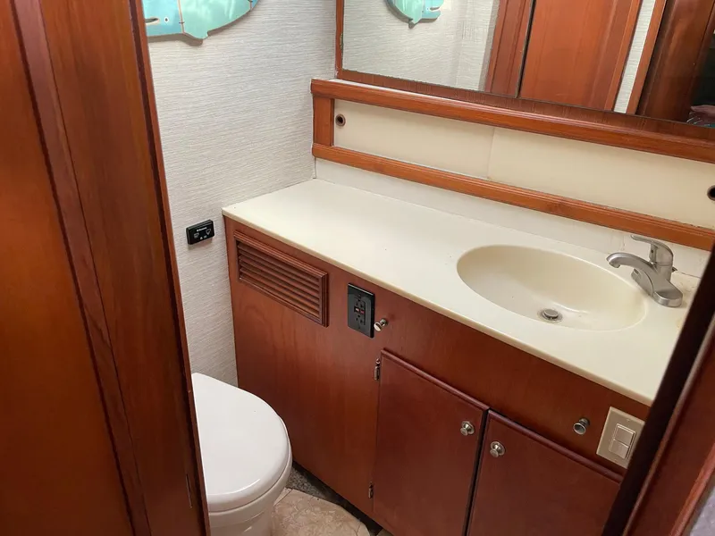 Slide: The Image of 1986 Egg Harbor 41 Convertible yacht bathroom with sink, toilet, and wooden cabinetry. - 11