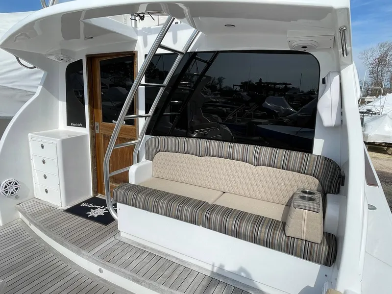 Slide: The Image of 1986 Egg Harbor 41 Convertible yacht with striped seating and wooden door on deck. - 34