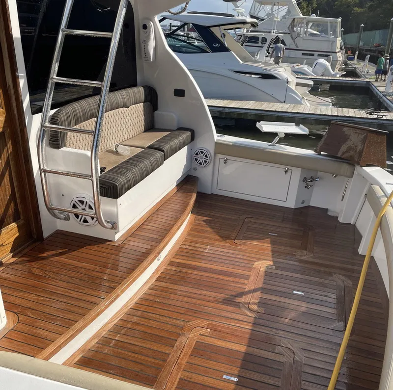 Slide: The Image of 1986 Egg Harbor 41 Convertible yacht with wooden deck and seating area at marina. - 36