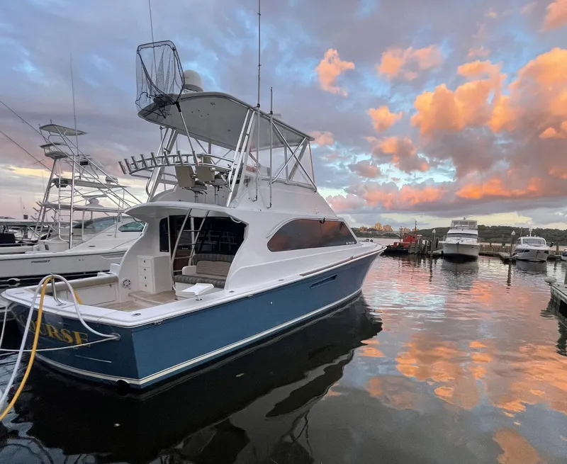 Slide: The Image of 1986 Egg Harbor 41 Convertible yacht docked at sunset with vibrant sky reflections. - 41