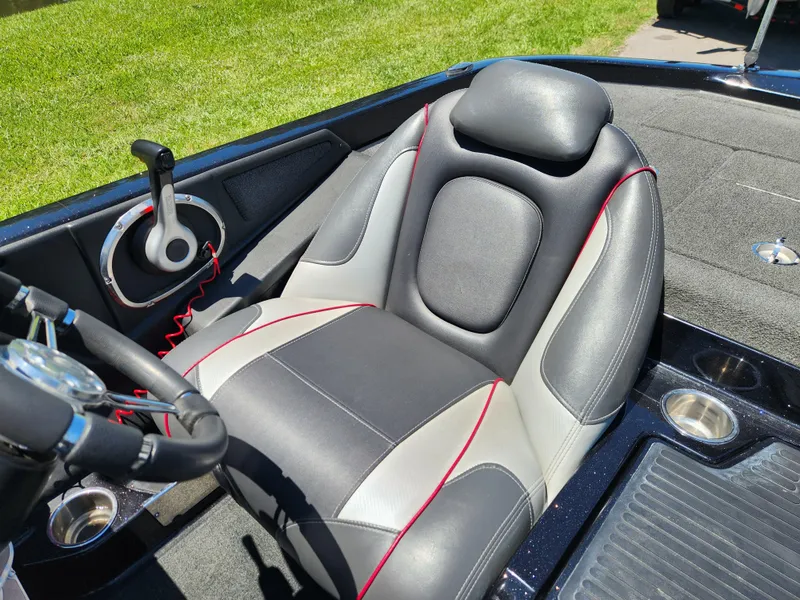 Slide: The Image of 2017 Ranger Z518 boat seat with steering wheel, black and gray upholstery, red accents, on grassy background. - 12