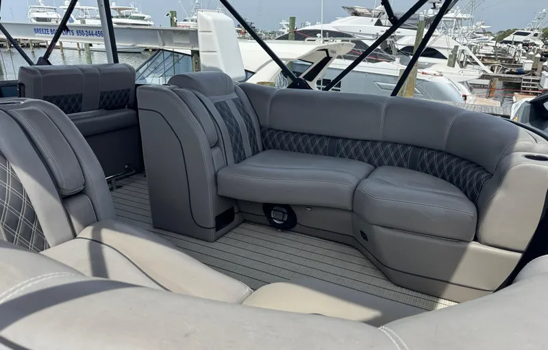 Slide: The Image of 2021 Barletta L25UE pontoon boat with luxurious gray seating at a marina. - 10