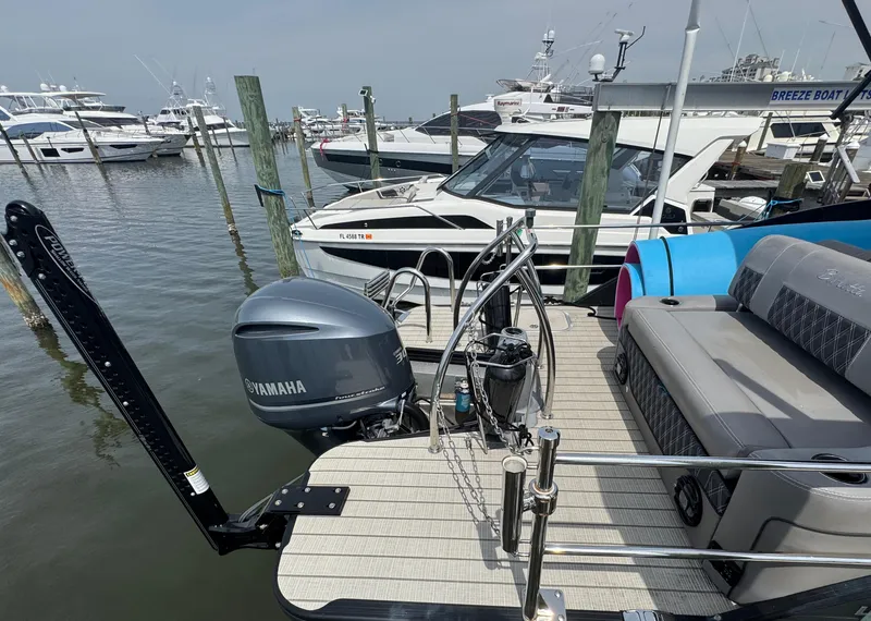 Slide: The Image of 2021 Barletta L25UE pontoon boat docked, featuring Yamaha outboard motor, in a marina setting. - 14