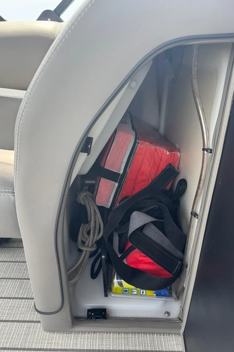 Slide: The Image of Storage compartment in a 2021 Barletta L25UE boat, containing life jackets and accessories. - 20