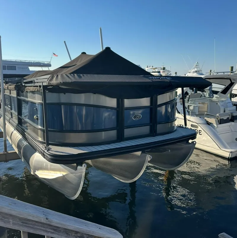 Slide: The Image of 2021 Barletta L25UE pontoon boat docked at marina under clear blue sky. - 24