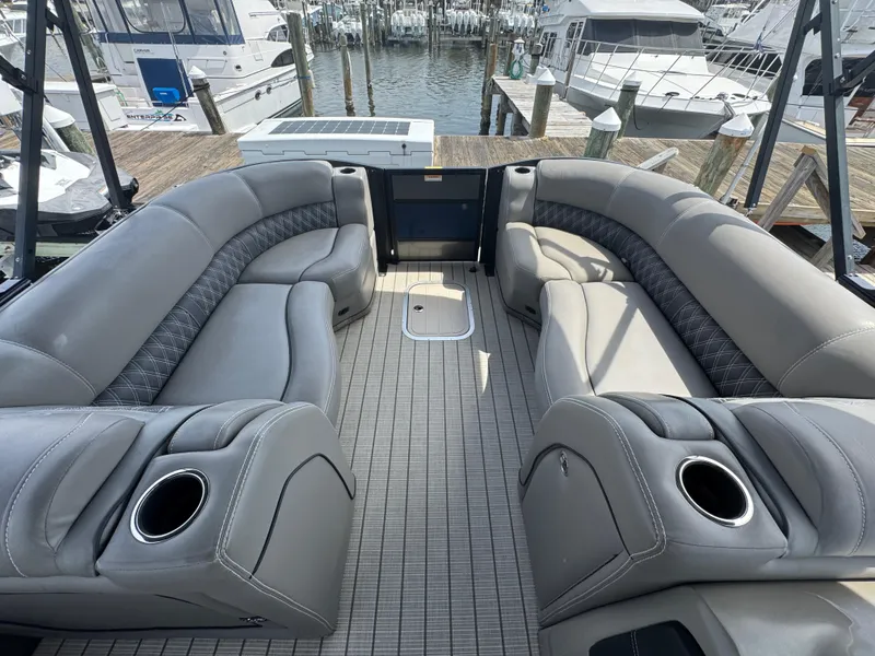 Slide: The Image of Luxurious 2021 Barletta L25UE pontoon boat interior with plush seating and cup holders. - 5