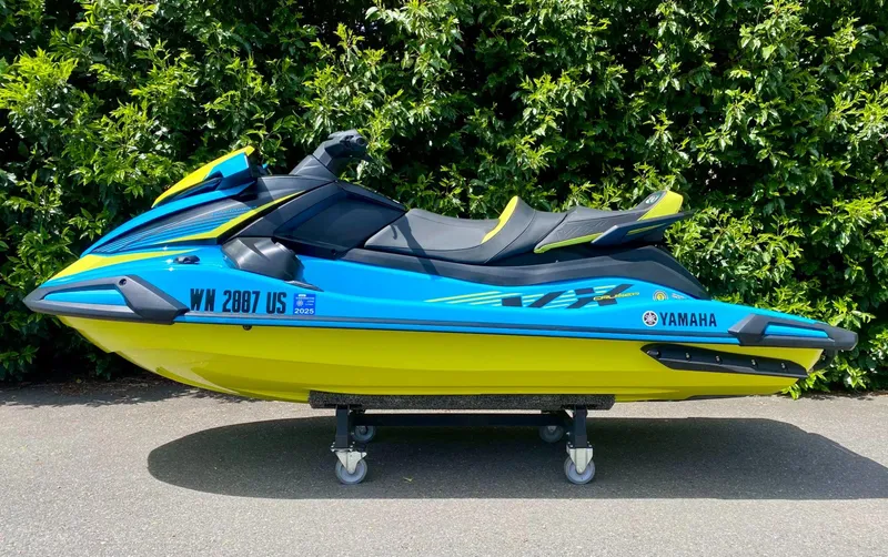 Slide: The Image of 2023 Yamaha VX Cruiser with Audio, blue and yellow, parked on pavement, lush green background. - 2