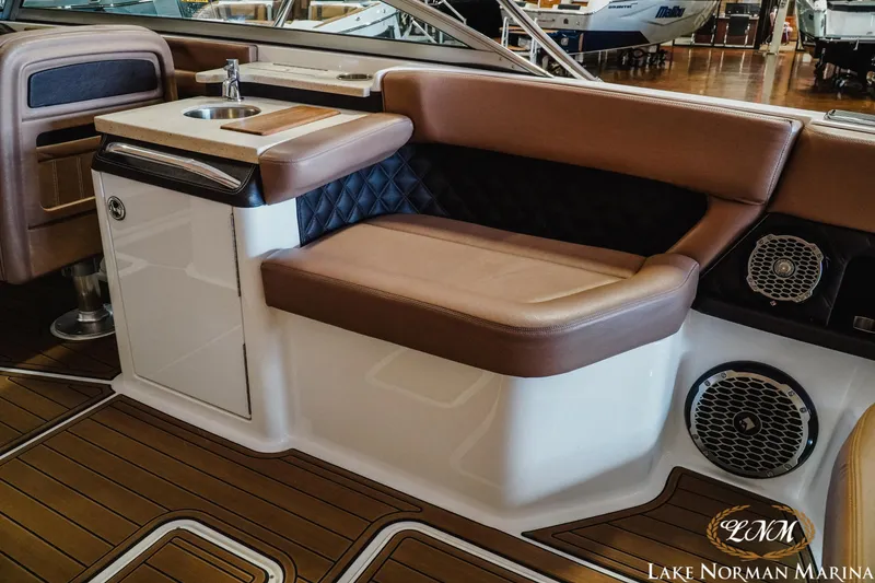 Slide: The Image of Interior of a 2013 Cobalt A28 boat with brown seating and wood flooring. - 11