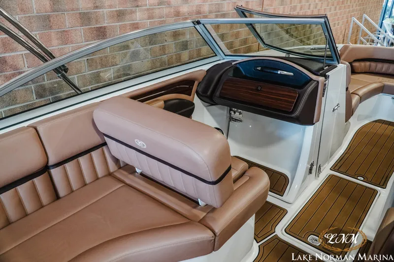 Slide: The Image of 2013 Cobalt A28 boat interior with tan leather seating and wood accents. - 13