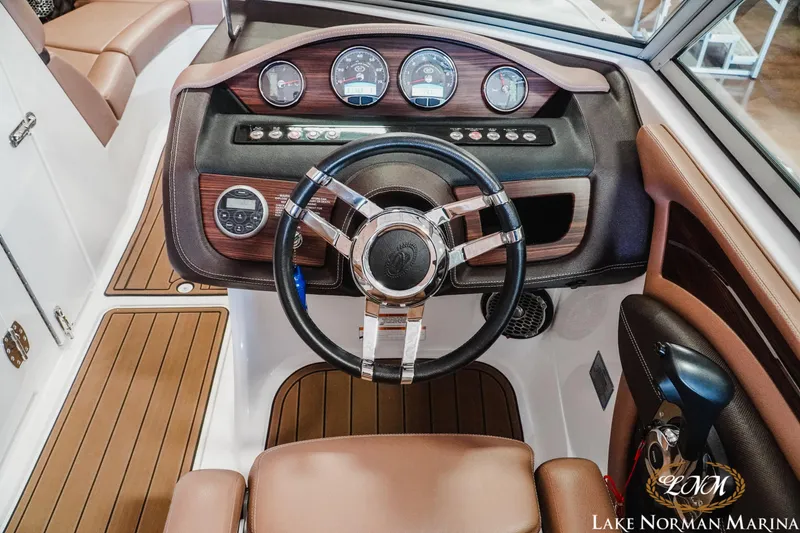 Slide: The Image of 2013 Cobalt A28 boat dashboard with wood accents and modern controls at Lake Norman Marina. - 14