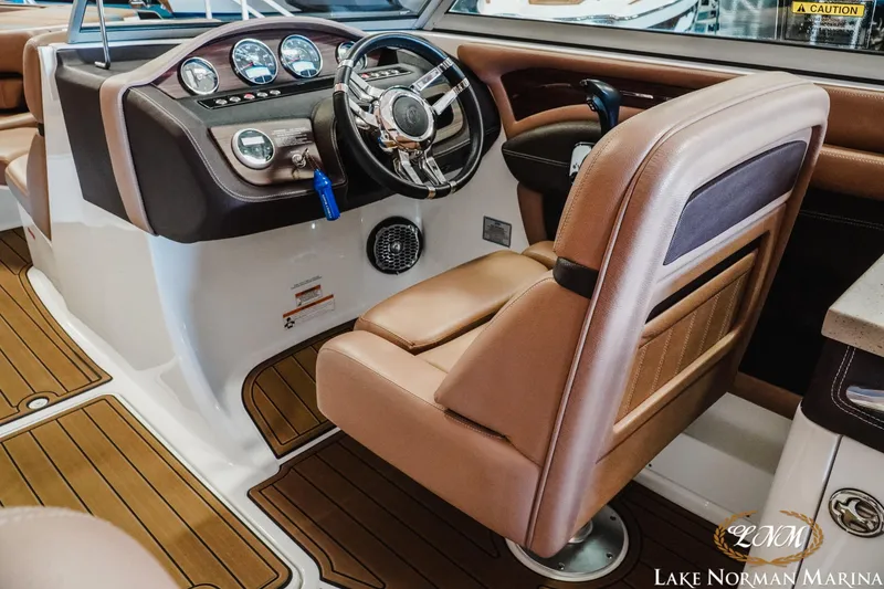 Slide: The Image of 2013 Cobalt A28 boat interior with brown leather seating and modern dashboard controls. - 16