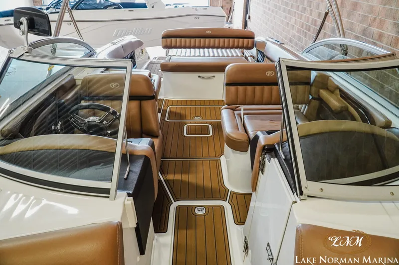 Slide: The Image of Interior of a 2013 Cobalt A28 boat with brown leather seating and wood flooring. - 19