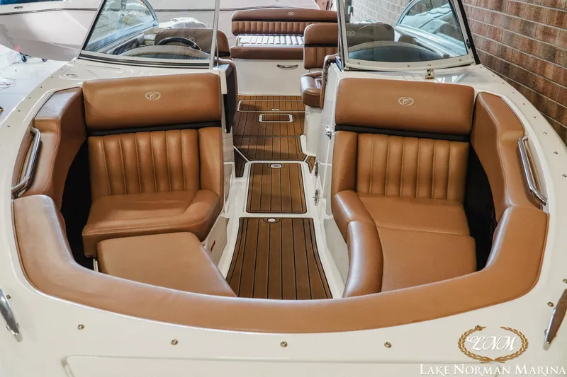 Slide: The Image of 2013 Cobalt A28 boat interior with brown leather seats and wooden flooring at Lake Norman Marina. - 5