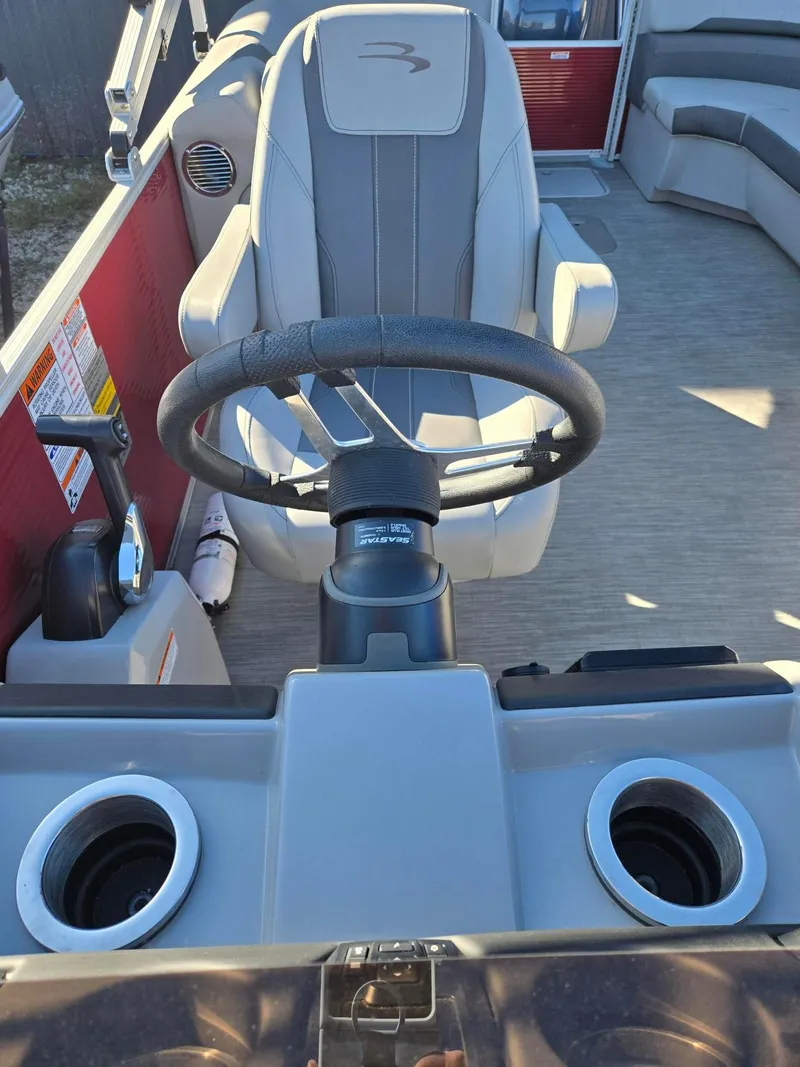 Slide: The Image of Captain's chair and steering wheel of 2023 Bennington 22SXSRC pontoon boat interior. - 18