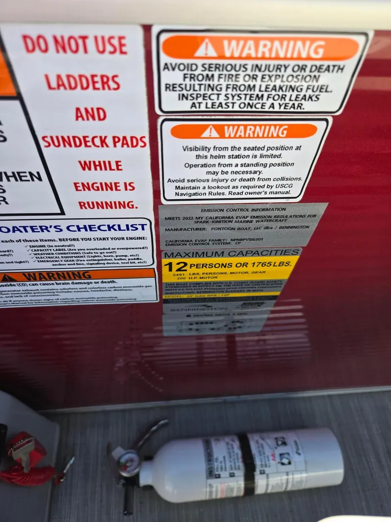 Slide: The Image of Warning labels and capacity information on a 2023 Bennington 22SXSRC boat. - 21
