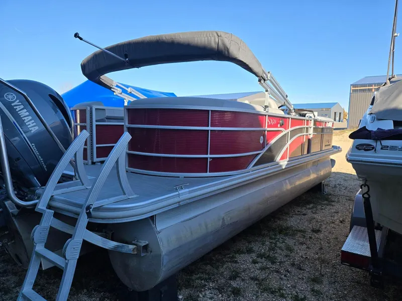 Slide: The Image of 2023 Bennington 22SXSRC pontoon boat with Yamaha engine, parked outdoors. - 4