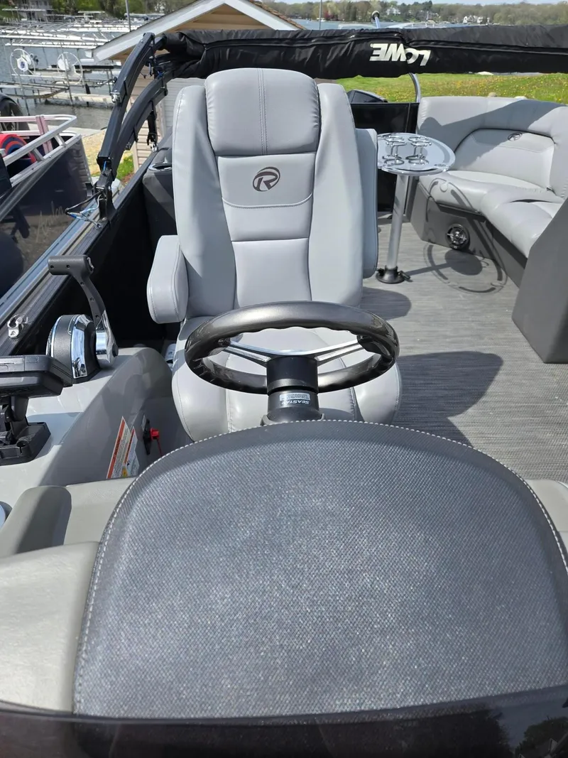 Slide: The Image of 2021 Lowe Retreat 230 High Performance boat interior with steering wheel and seating. - 10