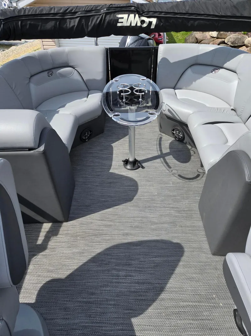 Slide: The Image of 2021 Lowe Retreat 230 High Performance boat interior with gray seating and table. - 12
