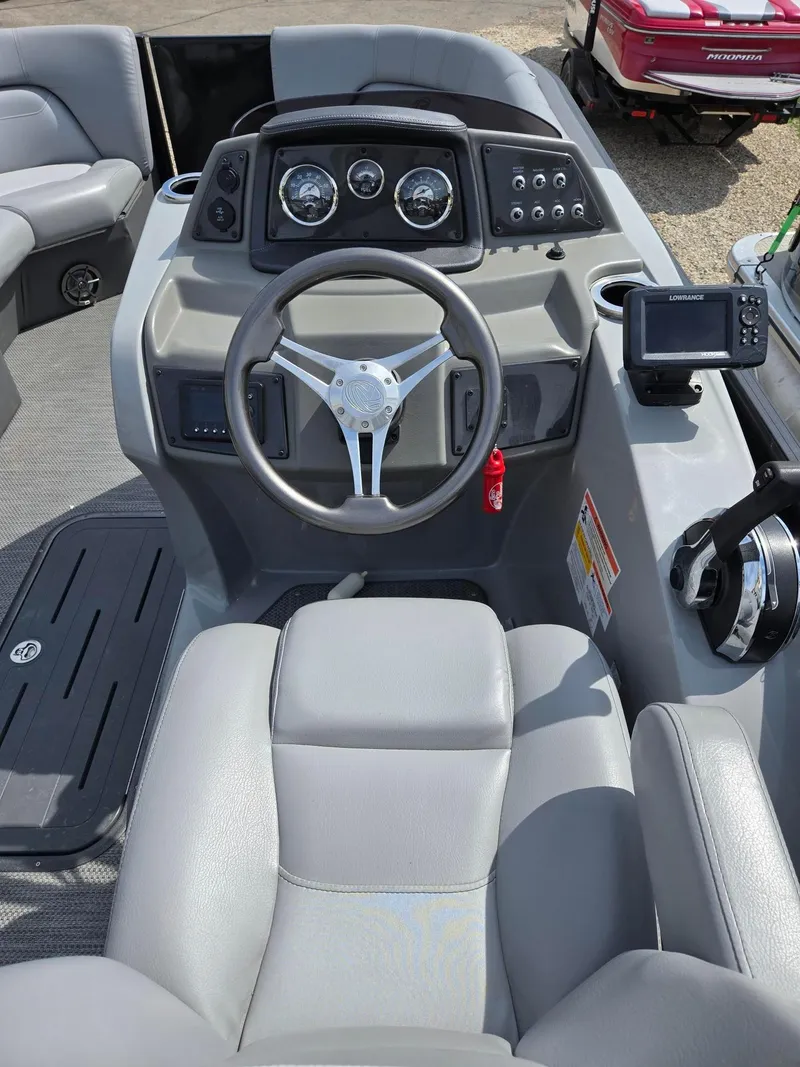 Slide: The Image of 2021 Lowe Retreat 230 High Performance boat dashboard with steering wheel and controls. - 18