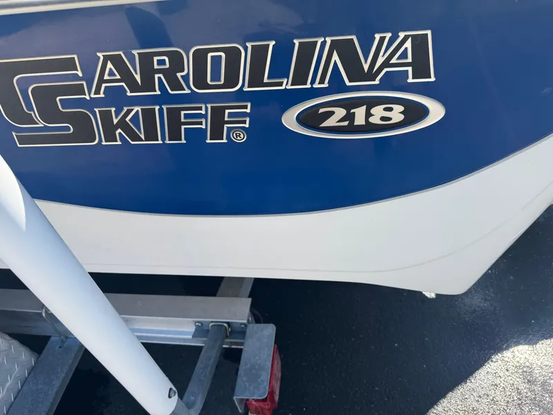 Slide: The Image of 2014 Carolina Skiff 218 DLV boat on trailer, blue and white design. - 3