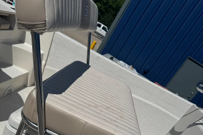 Slide: The Image of 2014 Carolina Skiff 218 DLV boat seat with white upholstery and metal frame. - 9