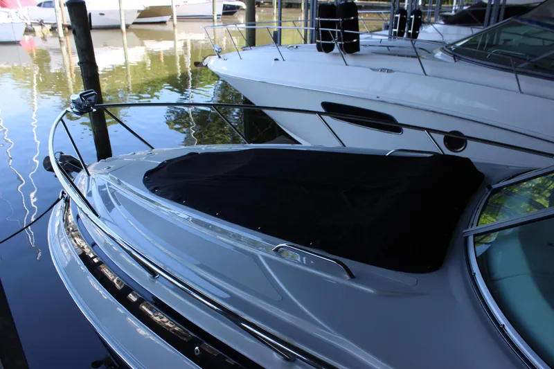Slide: The Image of 2021 Crownline 294 CR boat docked, featuring sleek design and covered bow area. - 1