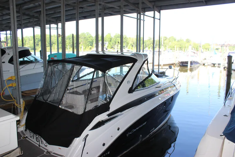 Slide: The Image of 2021 Crownline 294 CR boat docked under a covered marina. - 11