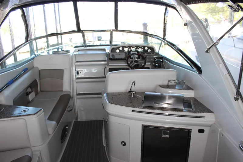 Slide: The Image of 2021 Crownline 294 CR boat interior with helm, seating, and kitchenette. - 13