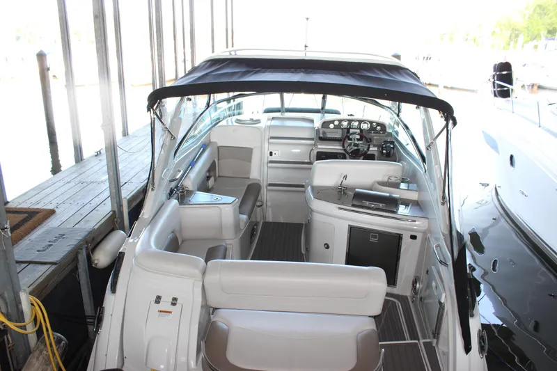 Slide: The Image of 2021 Crownline 294 CR boat interior with seating and helm under a canopy. - 2