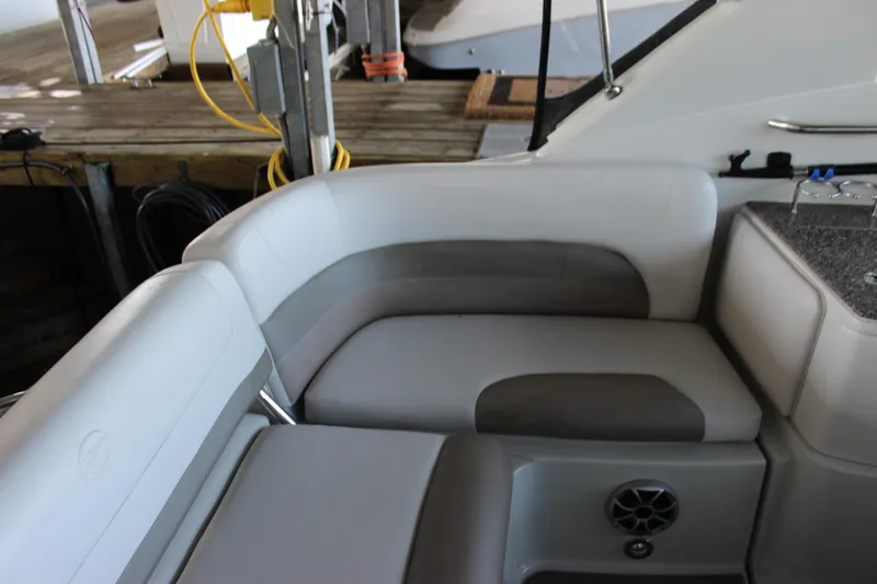 Slide: The Image of 2021 Crownline 294 CR boat interior with gray and white seating, docked at marina. - 20