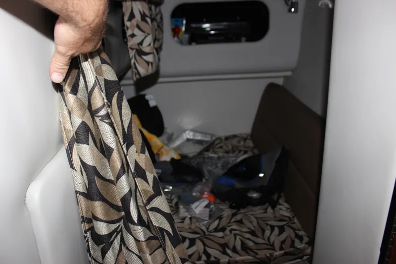 Slide: The Image of Interior cabin of 2021 Crownline 294 CR boat with patterned curtains and seating. - 29