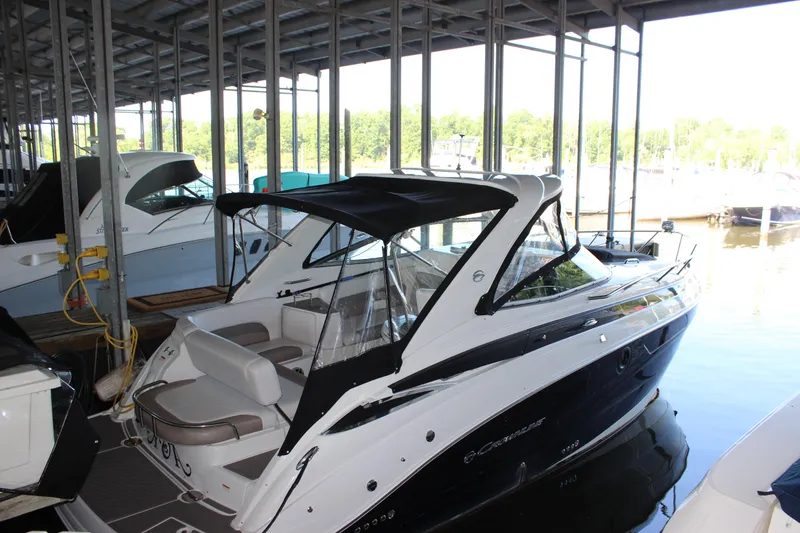 Slide: The Image of 2021 Crownline 294 CR boat docked in a marina under a covered structure. - 3
