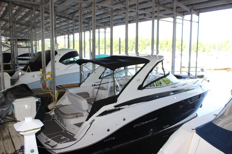 Slide: The Image of 2021 Crownline 294 CR boat docked in a covered marina. - 4