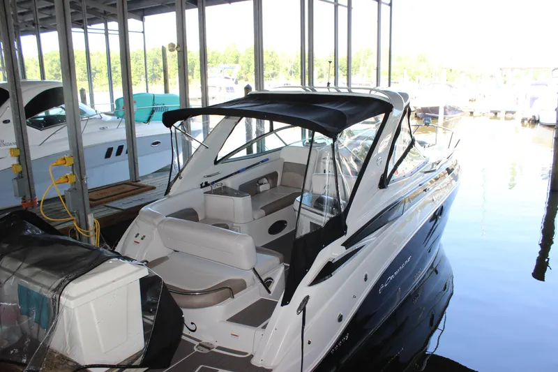 Slide: The Image of 2021 Crownline 294 CR boat docked in a marina, featuring sleek design and spacious seating. - 5