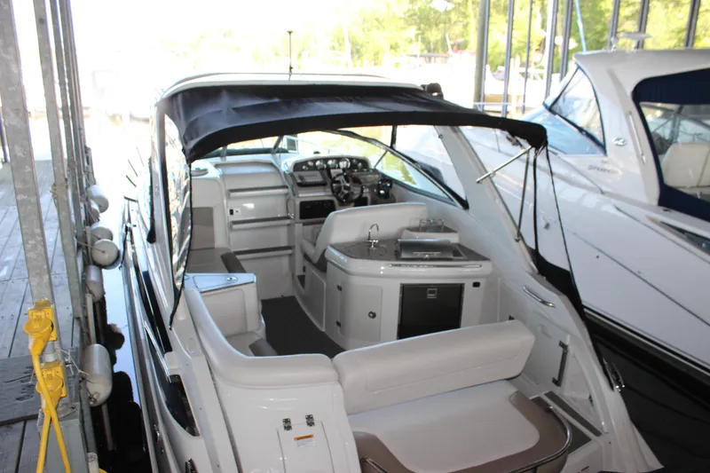 Slide: The Image of 2021 Crownline 294 CR boat interior with seating and helm, docked in a marina. - 7