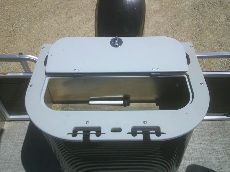 Slide: The Image of 2022 Qwest 816 Edge 4 Point Fish boat storage compartment, open lid, outdoor setting. - 14