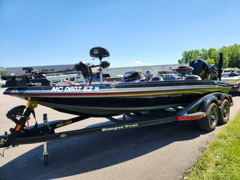 Slide: The Image of 2022 Ranger Z519 boat on trailer, parked outdoors under clear blue sky. - 6