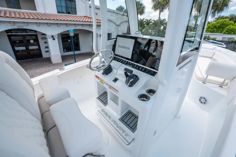 Slide: The Image of 2025 Sea Hunt Ultra 245 SE boat interior with Garmin navigation system and sleek white seating. - 21