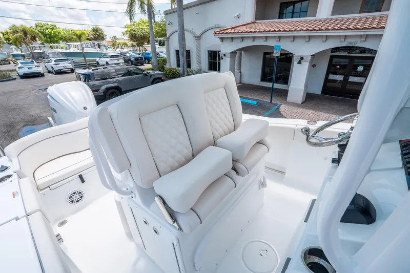 Slide: The Image of 2025 Sea Hunt Ultra 245 SE boat interior with plush seating and steering wheel. - 23