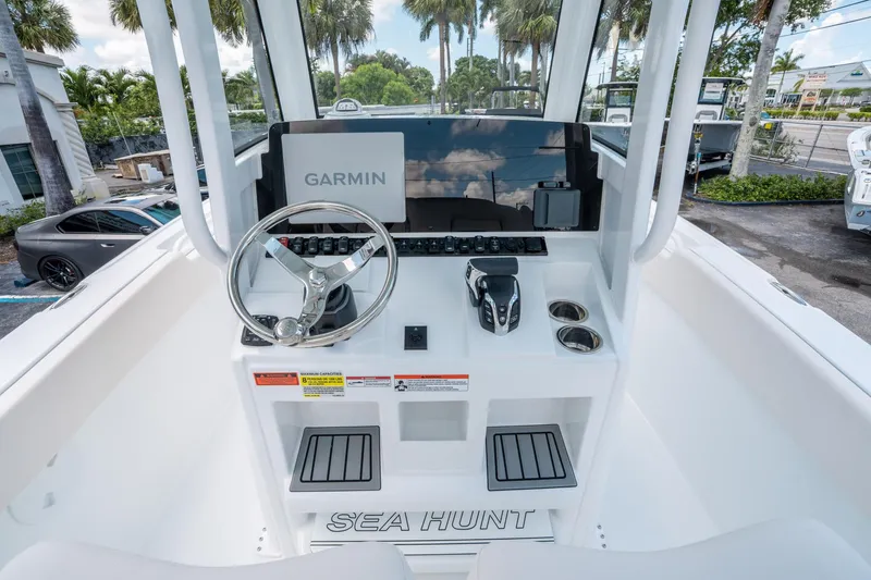 Slide: The Image of 2025 Sea Hunt Ultra 245 SE boat console with Garmin navigation system and steering wheel. - 19