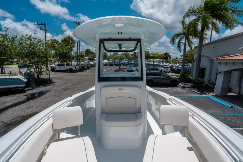 Slide: The Image of 2025 Sea Hunt Ultra 245 SE boat interior with seating, under a clear blue sky. - 28