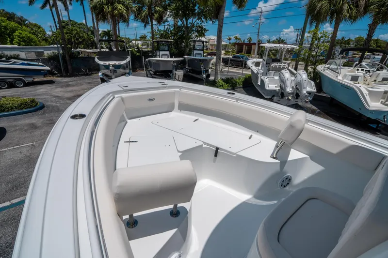 Slide: The Image of 2025 Sea Hunt Ultra 245 SE boat interior with seating, displayed outdoors under palm trees. - 29