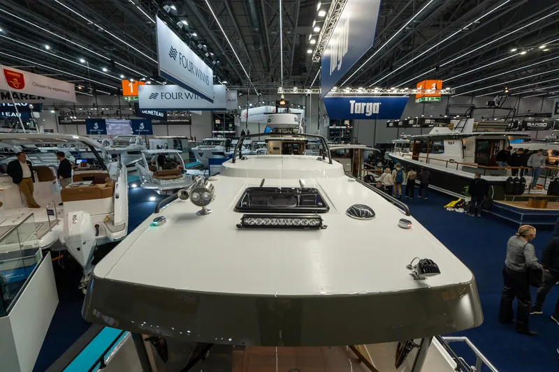 Slide: The Image of 2026 Targa 27 boat showcased at a bustling indoor exhibition with various marine displays. - 10