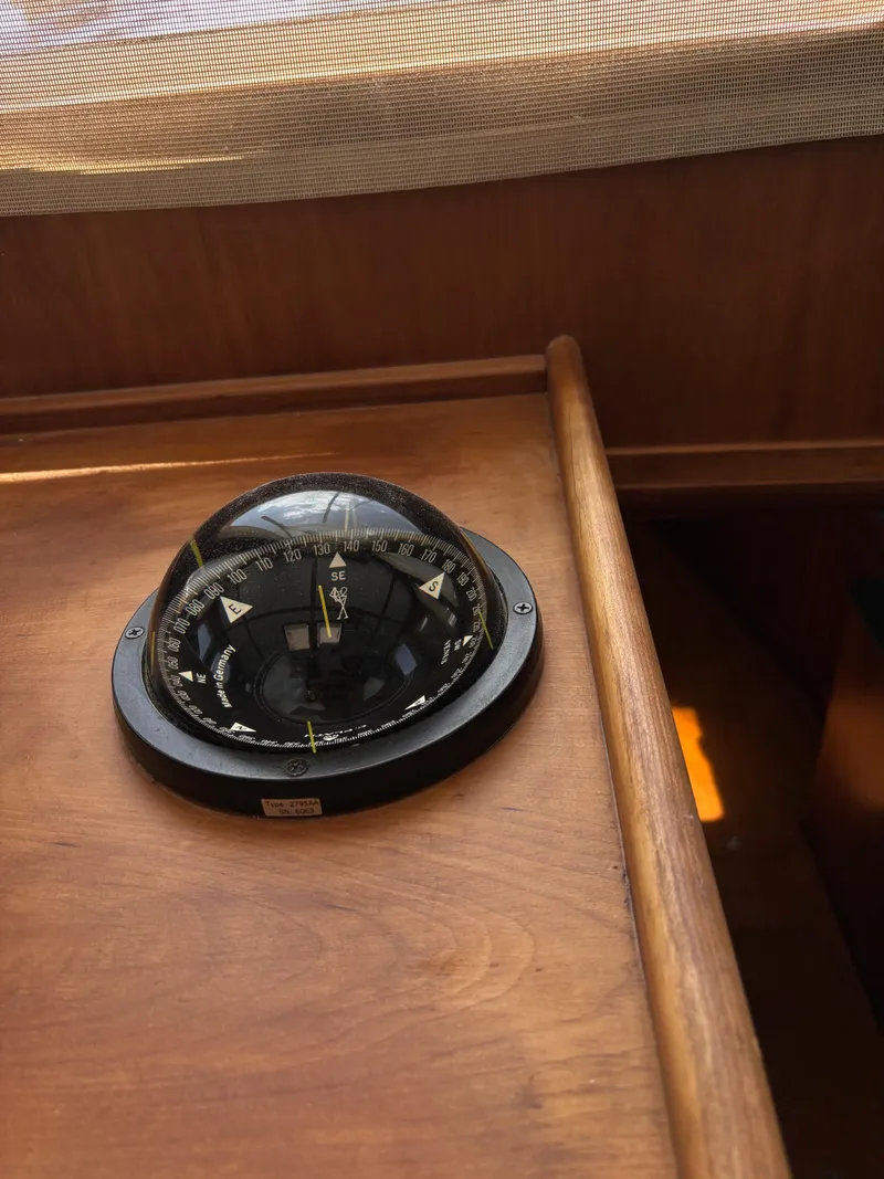 Slide: The Image of Compass on 1999 Diesel Duck Trawler's wooden dashboard, under soft lighting. - 15
