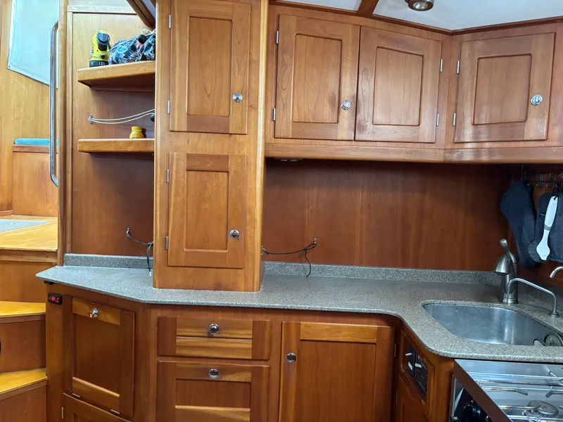 Slide: The Image of 1999 Diesel Duck Trawler kitchen with wooden cabinets and modern sink. - 18