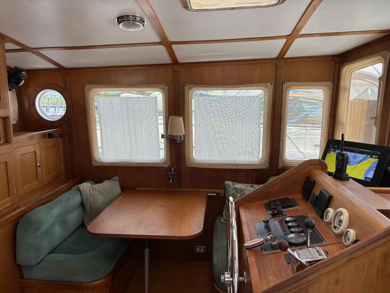 Slide: The Image of 1999 Diesel Duck Trawler interior with wooden helm, seating, and navigation equipment. - 3