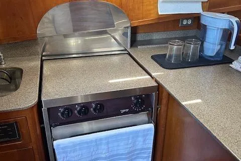 Slide: The Image of Diesel Duck 1999 Trawler kitchen with stove, countertop, and water filter pitcher. - 30